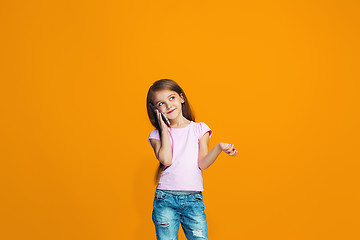 Image showing The happy teen girl standing and smiling with phone