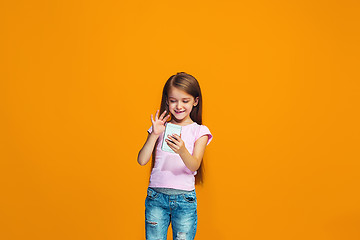 Image showing The happy teen girl standing and smiling with phone