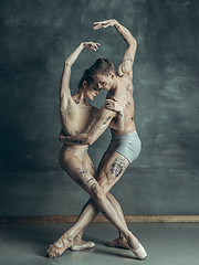 Image showing The young modern ballet dancers posing on gray studio background