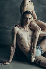 Image showing The young modern ballet dancers posing on gray studio background