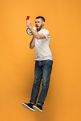 Image showing Football supporter with red card on orange background