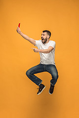 Image showing Football supporter with red card on orange background