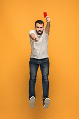 Image showing Football supporter with red card on orange background