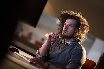 Image showing man working on computer in dark office