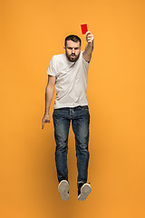 Image showing Football supporter with red card on orange background