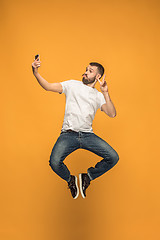 Image showing Time to take selfie. Full length of handsome young man taking selfie while jumping