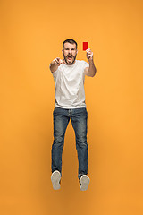 Image showing Football supporter with red card on orange background