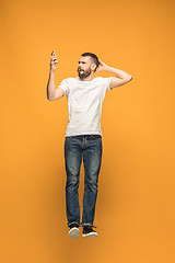 Image showing Full length of handsome young man taking selfie while jumping