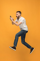 Image showing Full length of handsome young man taking selfie while jumping