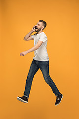 Image showing Full length of handsome young man taking selfie while jumping