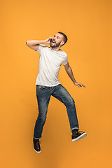 Image showing Full length of handsome young man taking selfie while jumping