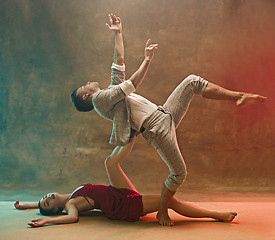 Image showing Flexible young modern dance couple posing in studio.