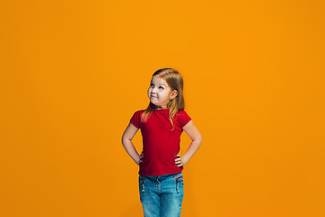 Image showing The happy teen girl standing and smiling against orange background.