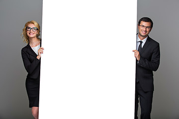 Image showing Businessman and business woman with big empty poster