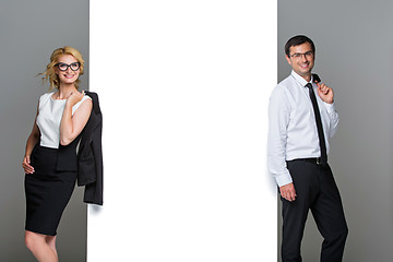 Image showing Businessman and business woman with big empty poster