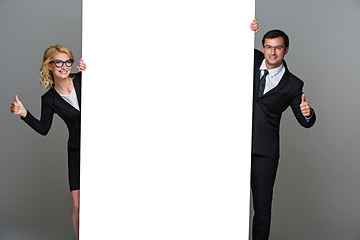 Image showing Businessman and business woman with big empty poster