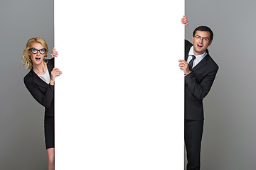 Image showing Businessman and business woman with big empty poster