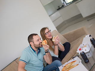 Image showing couple eating pizza in their luxury home villa