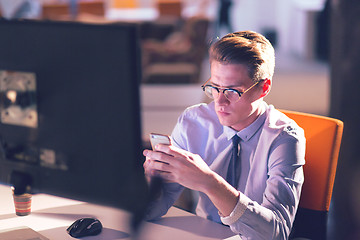 Image showing man using mobile phone in dark office