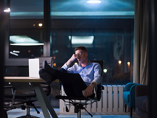 Image showing businessman sitting with legs on desk at office