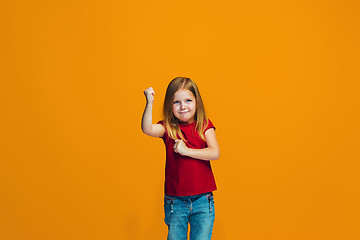 Image showing Portrait of angry teen girl on a orange studio background