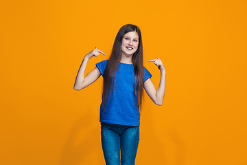 Image showing The happy teen girl standing and smiling against pink background.