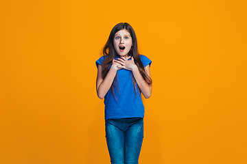 Image showing Beautiful teen girl looking suprised isolated on orange