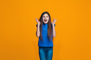 Image showing Beautiful teen girl looking suprised isolated on orange