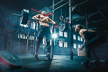 Image showing Fit young man lifting barbells working out in a gym