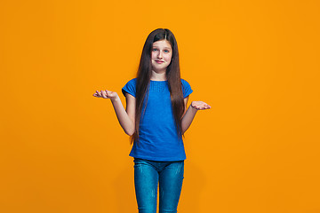 Image showing Beautiful teen girl looking suprised and bewildered isolated on orange