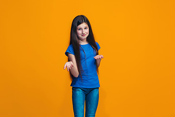 Image showing Beautiful teen girl looking suprised and bewildered isolated on orange