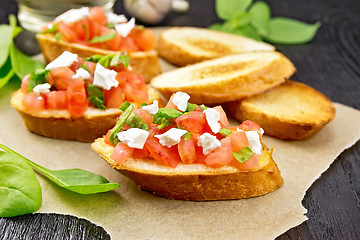 Image showing Bruschetta with tomato and cheese on dark board