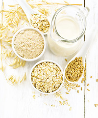 Image showing Oat flakes with flour and milk on board top