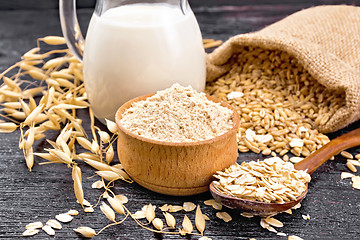 Image showing Flour oat in bowl with oatmeal on dark board