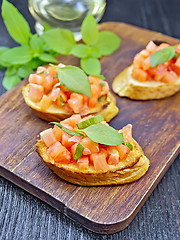 Image showing Bruschetta with tomato and basil on black board