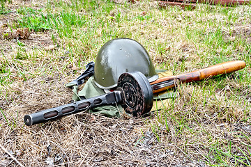 Image showing Helmet and submachine gun on ground