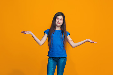 Image showing Beautiful teen girl looking suprised and bewildered isolated on orange