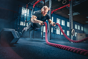 Image showing Men with battle rope battle ropes exercise in the fitness gym.