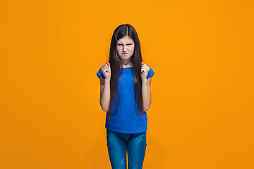 Image showing Portrait of angry teen girl on a orange studio background