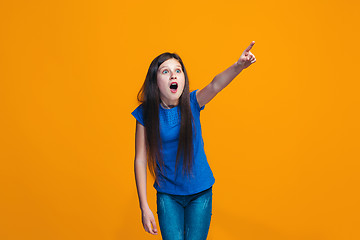 Image showing Beautiful teen girl looking suprised isolated on orange
