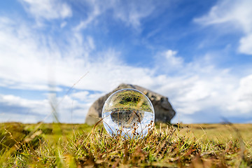 Image showing Glass orb on grass with reflection