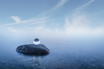 Image showing Crystal ball on a rock in a misty seascape