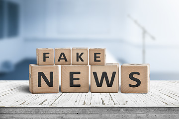 Image showing Fake news sign on a wooden desk in a blue room