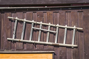 Image showing Wooden ladder hanging on the wall