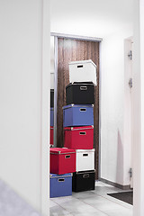 Image showing Stacked boxes in various colors in a bright room