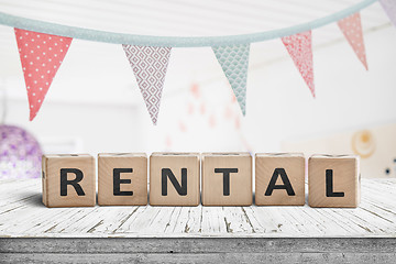 Image showing Rental sign with flags hanging over a wooden desk