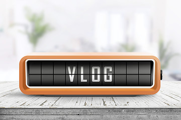 Image showing Vlog word written on a retro device in orange color