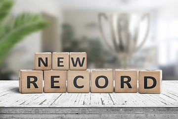 Image showing New record sign on a wooden table in a bright room
