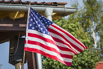 Image showing American flag on a porch outside a small cabin