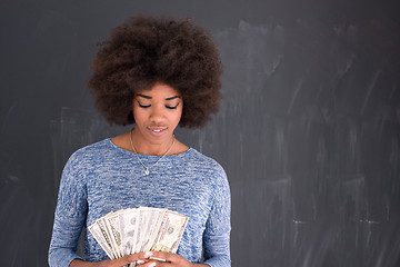 Image showing black woman holding money on gray background